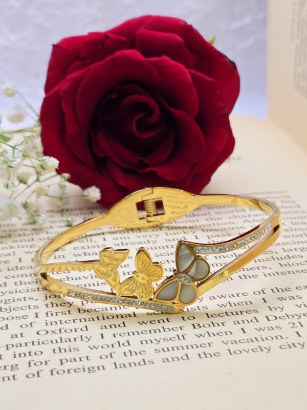Golden butterfly bangle with crystal accents.